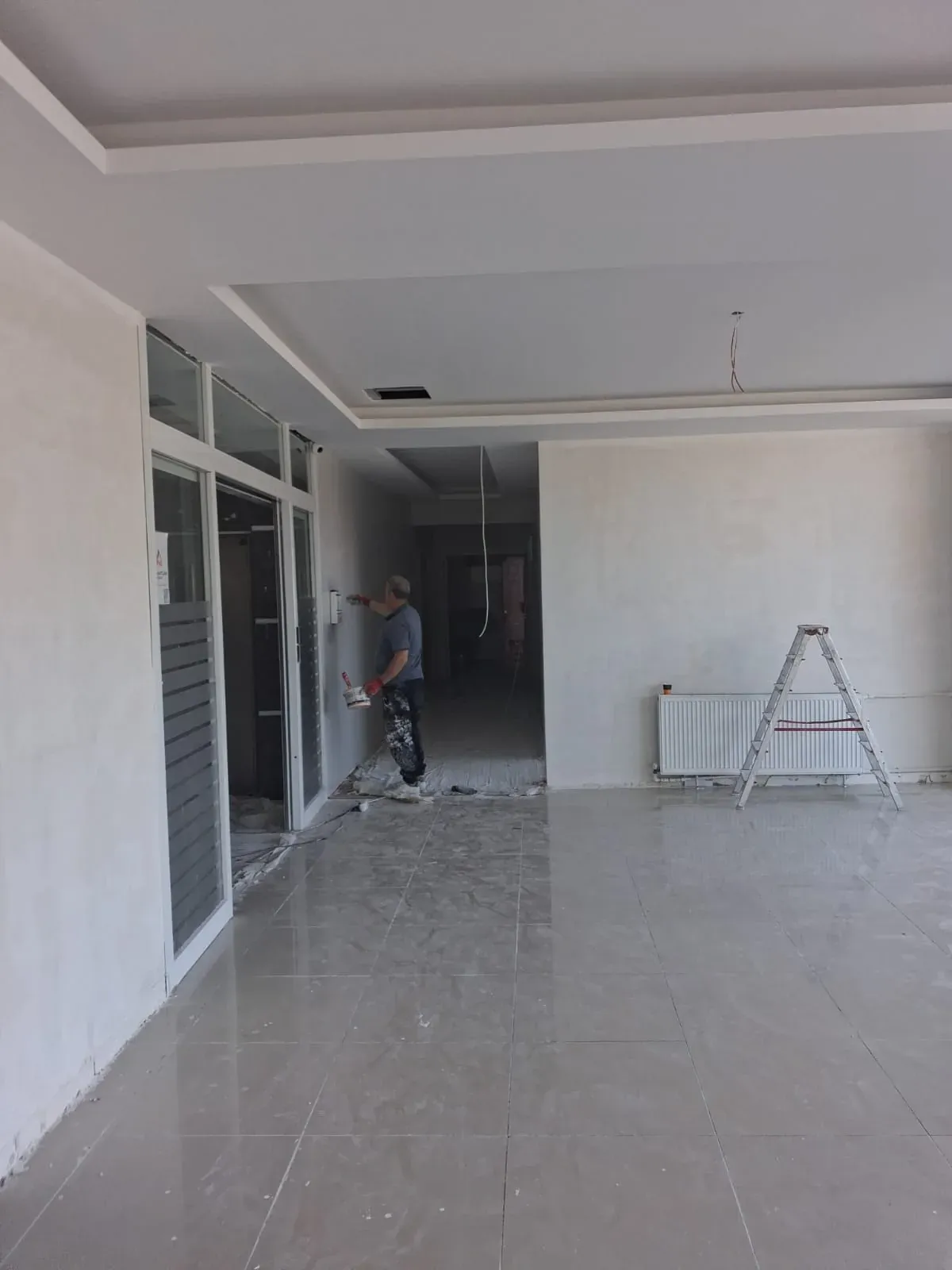 Bülent Usta duvara mala ile saten alçı uygularken — Darıca'da boya öncesi yüzey hazırlığı
